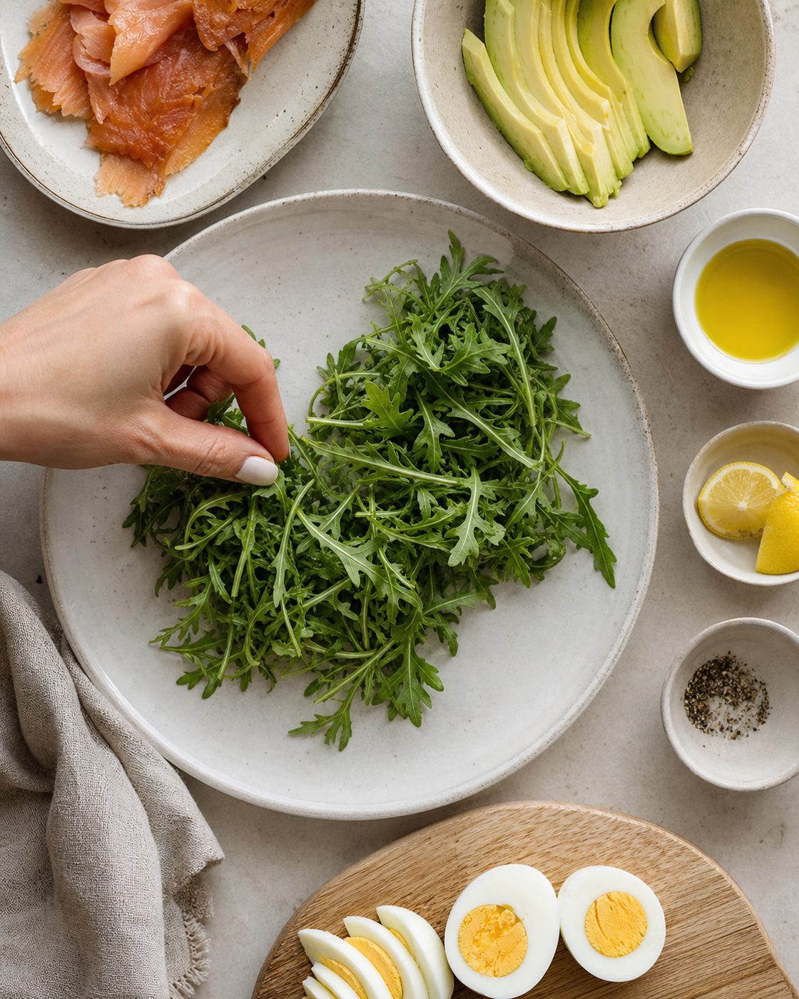 Schritt 1: Ich verteile den Rucola auf dem Teller und lege Forelle, Avocadospalten und das halbierte Ei darauf.
