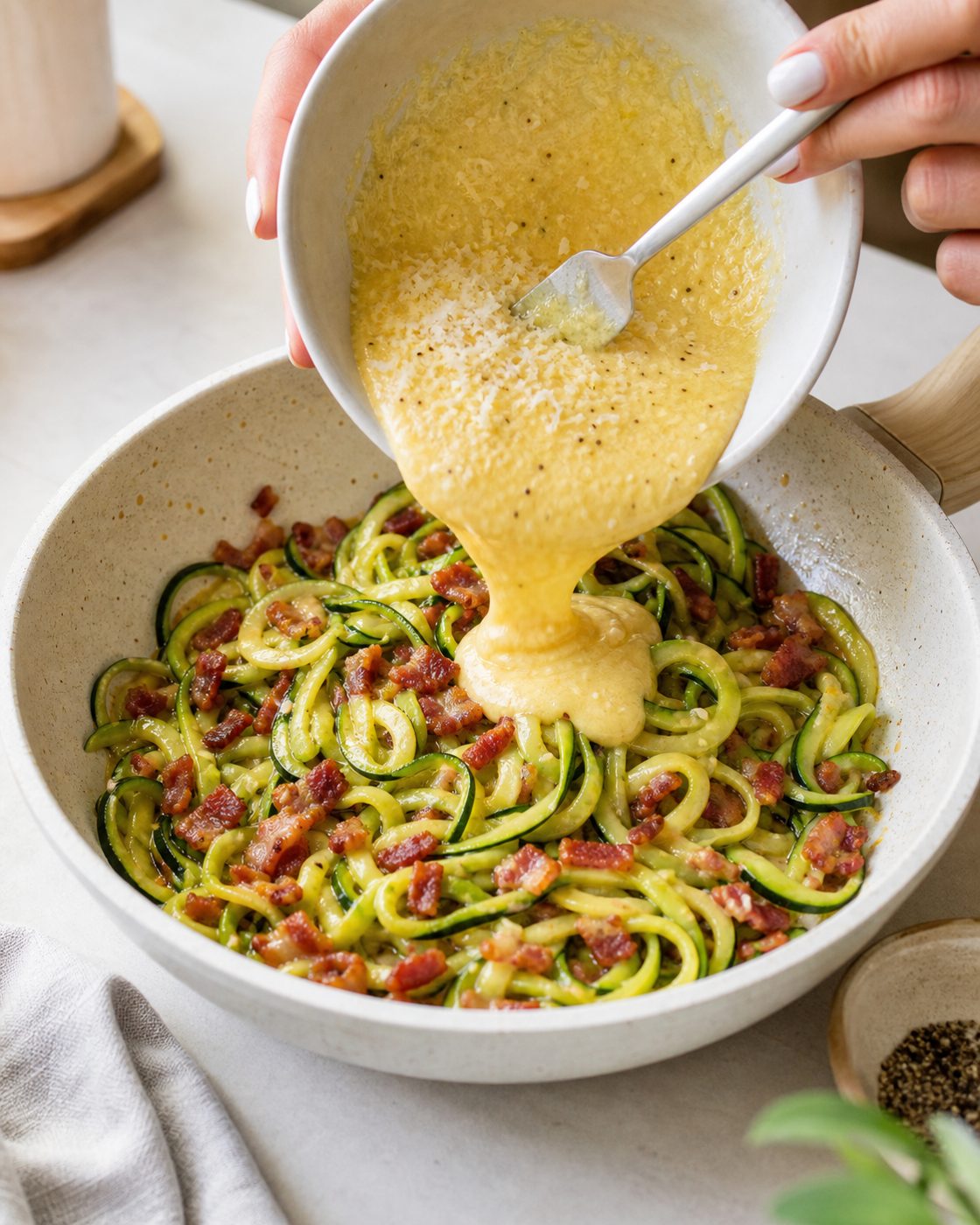 Schritt 2: Die Pfanne vom Herd nehmen und die Mischung aus Eigelb und Parmesan zügig unterheben.
