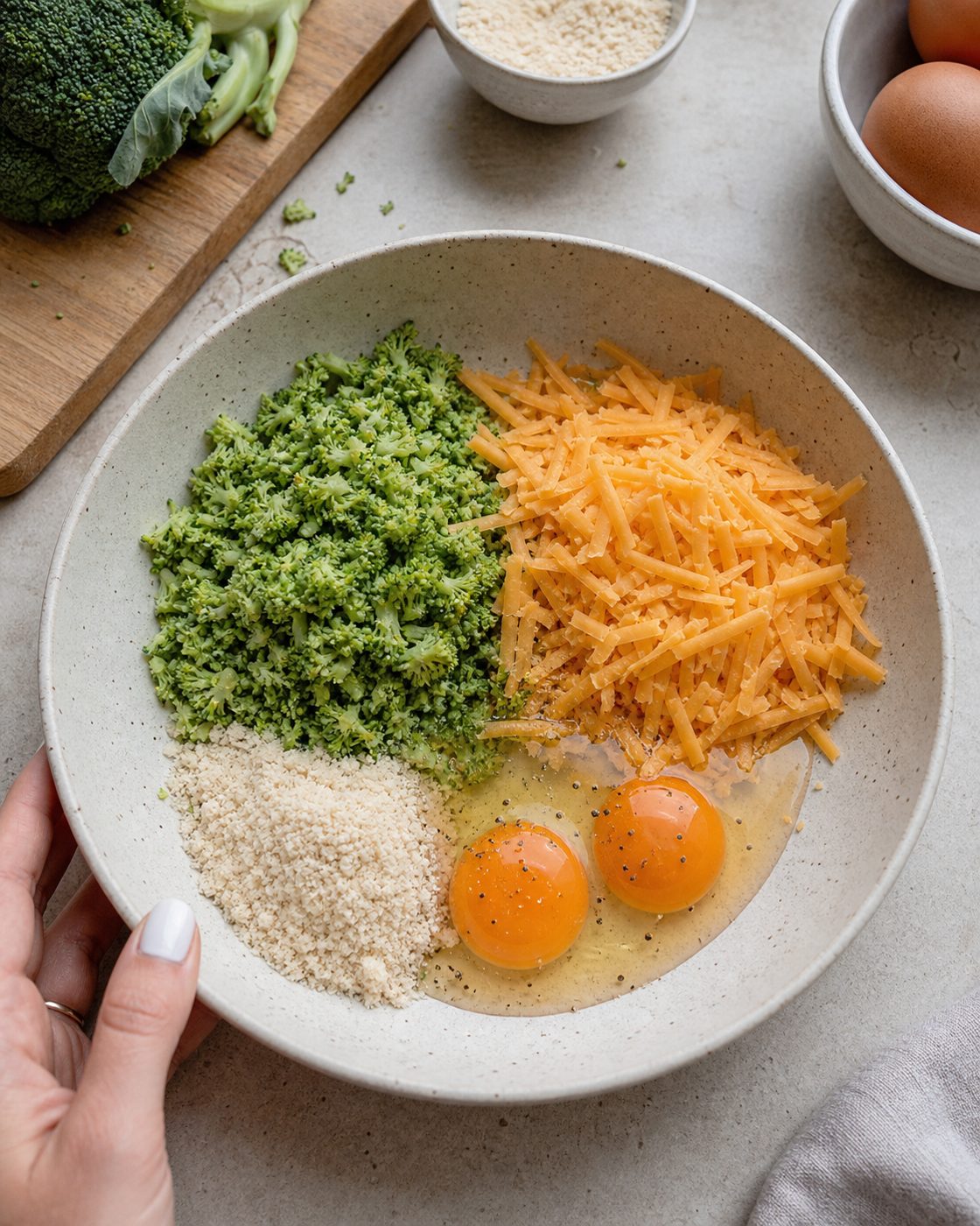Schritt 1: Den gegarten Brokkoli fein hacken, gut ausdrücken und mit Cheddar, Eiern und Mandelmehl mischen.