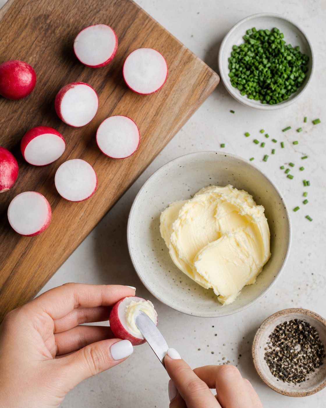 Schritt 1: Die Radieschen halbieren und die Schnittflächen mit weicher Butter bestreichen.