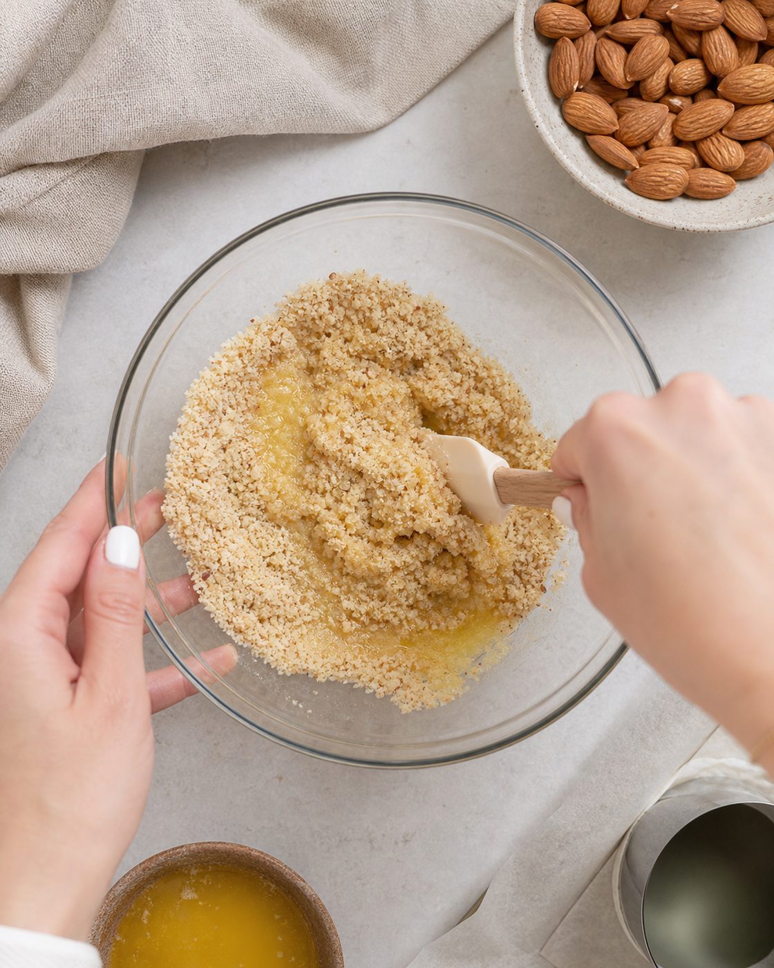 Schritt 1: Gemahlene Mandeln mit Butter mischen und fest in die Ringe drücken.