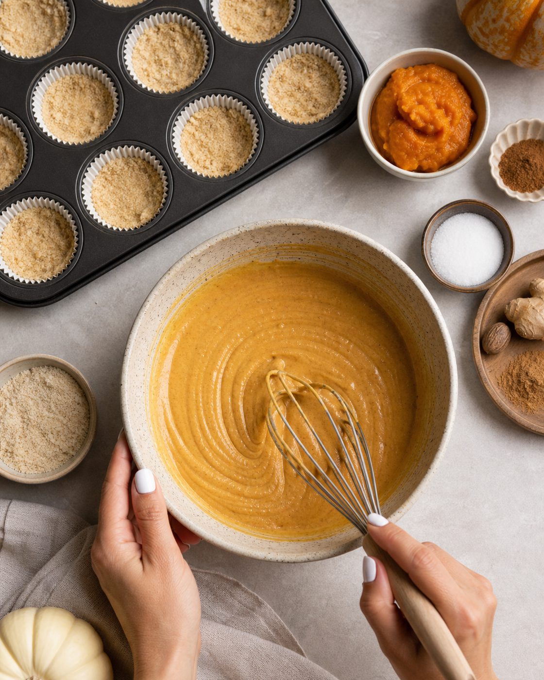 Schritt 1: Die gemahlenen Mandeln mit der Butter mischen und als Boden in zwölf Muffinförmchen drücken.