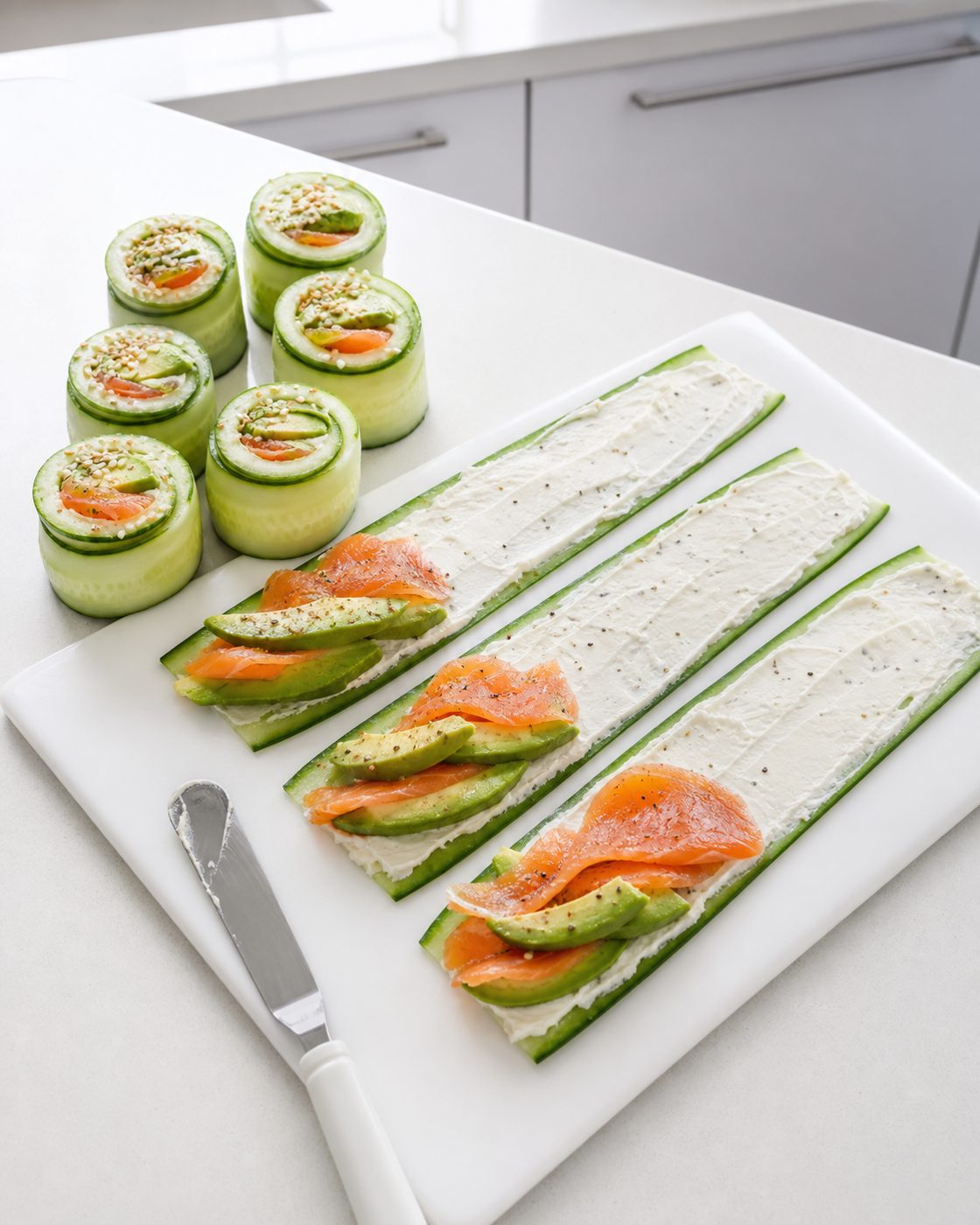 Schritt 2: Die Bänder mit Frischkäse, Avocado und Lachs belegen und fest aufrollen.