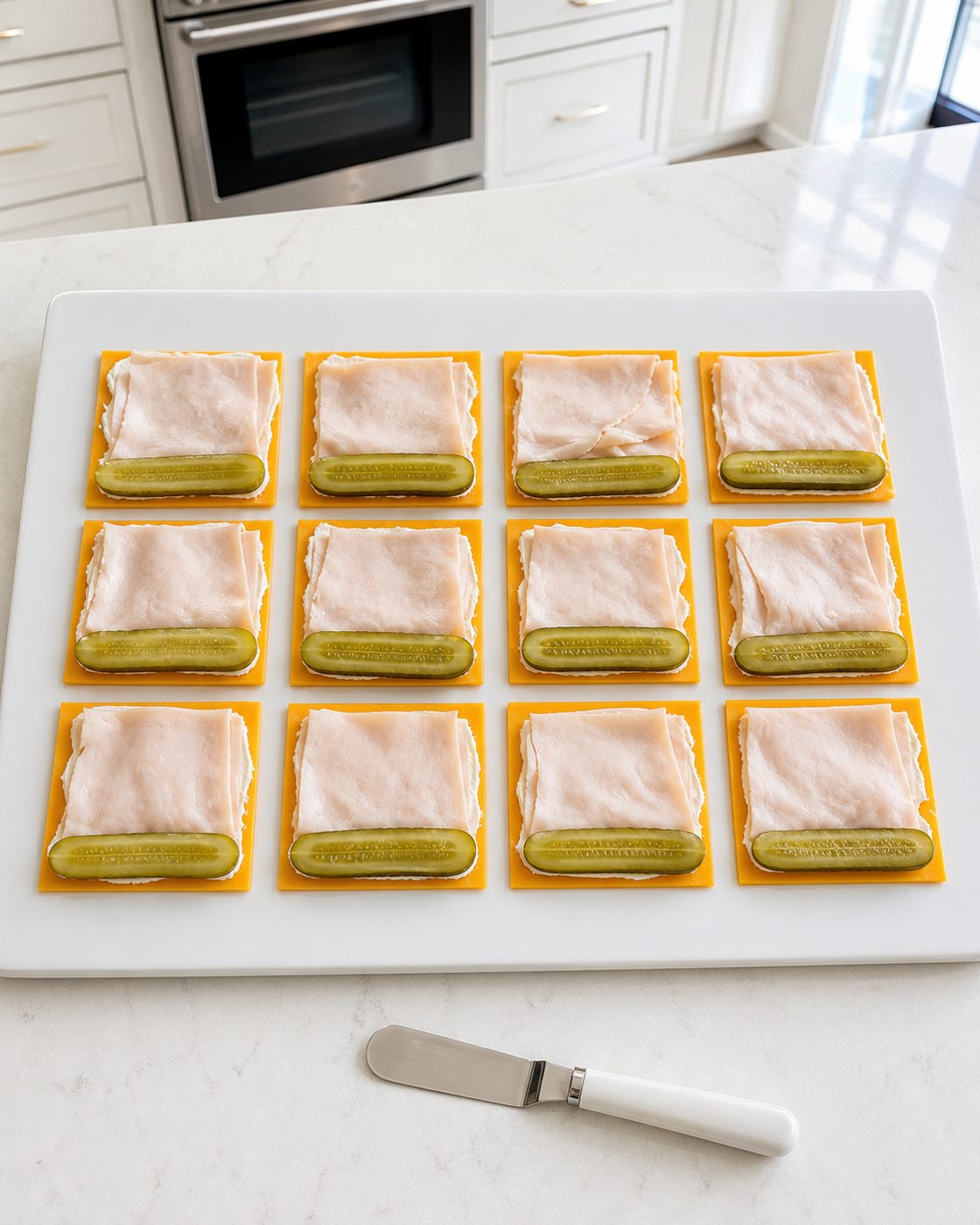 Schritt 2: Zwölf Aufbauten aus Cheddar, Pute und Gurke nebeneinander vorbereiten.