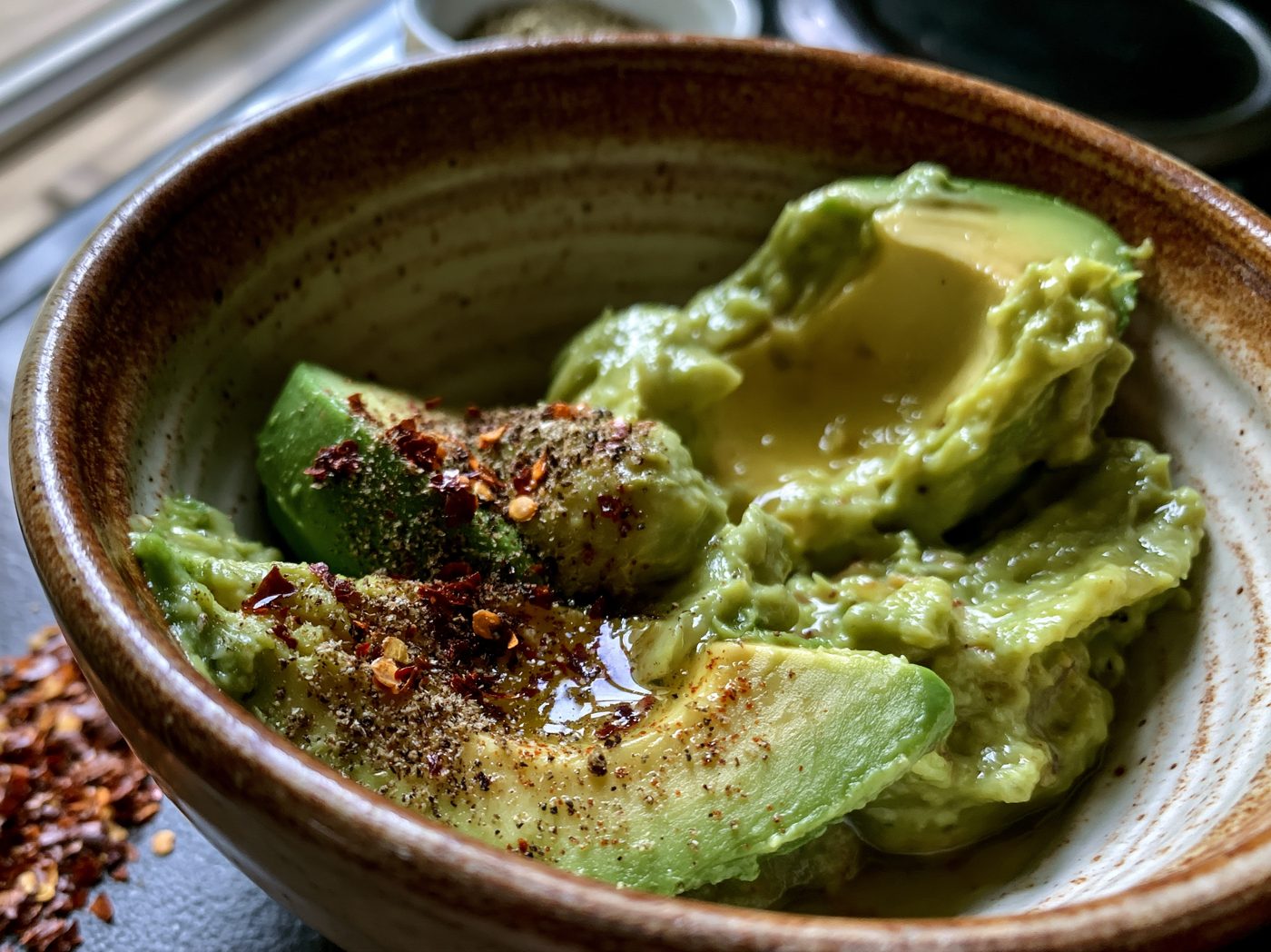 Avocado mit Zitrone, Salz und Chili in einer Schale zerdrückt